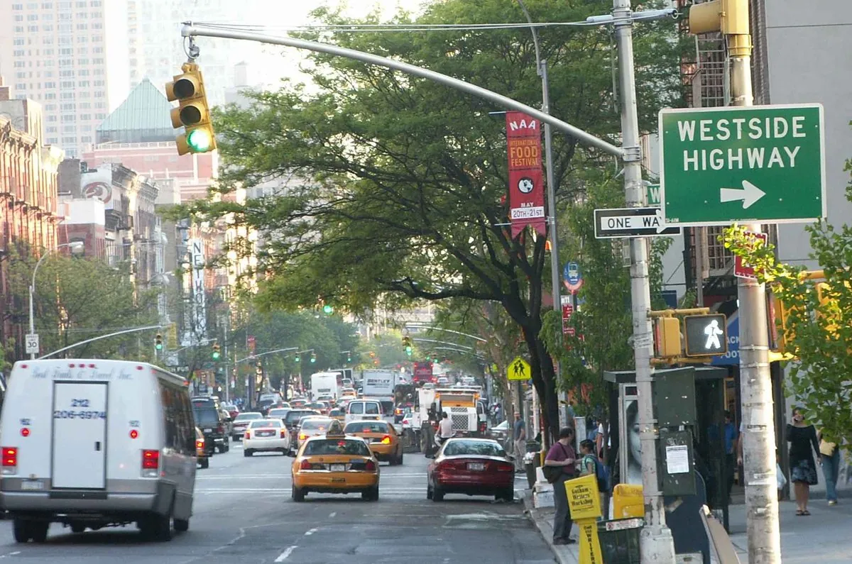 Sidewalk restaurant tables and food storefronts along Ninth Avenue in Hell’s Kitchen