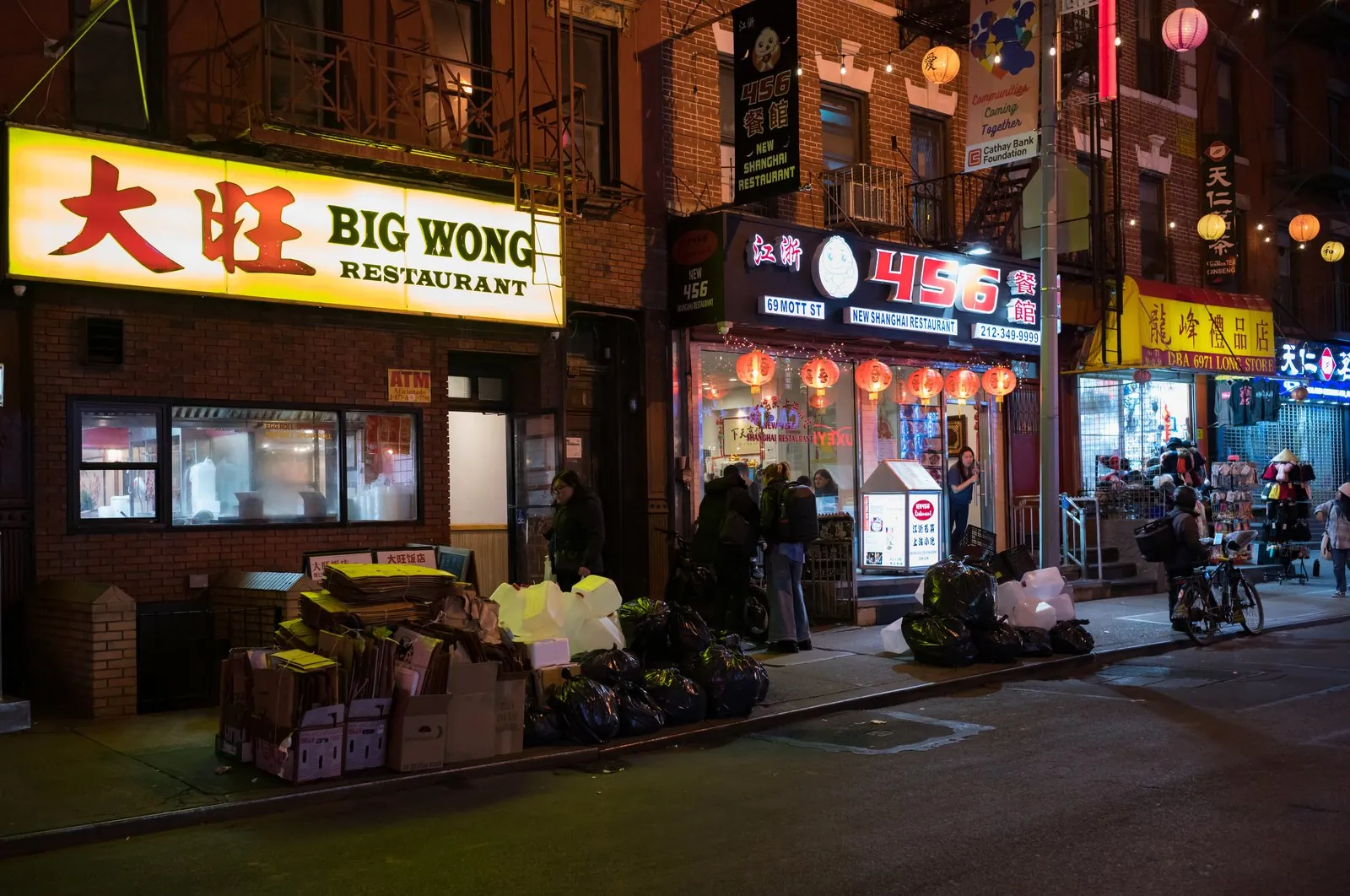 Busy Mott Street in Chinatown Manhattan lined with storefronts and banners