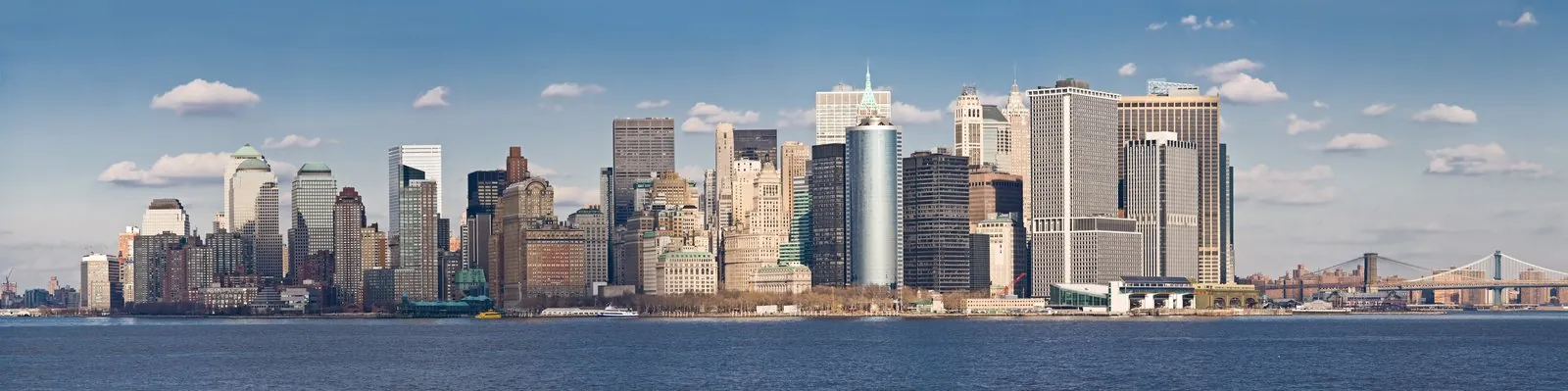 Lower Manhattan skyline illuminated across New York Harbor from Staten Island Ferry