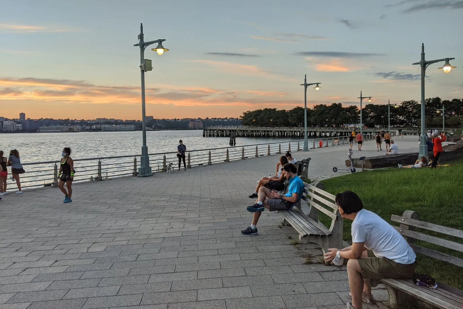 Hudson River Park waterfront promenade looking out toward Jersey City at sunset