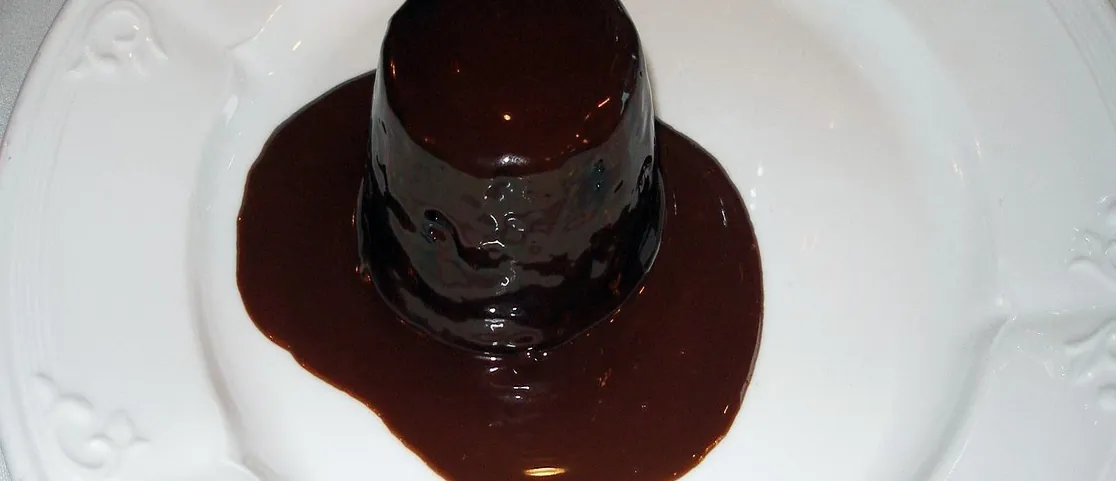 Plated molten chocolate lava cake dessert with rich chocolate sauce and ice cream at an evening restaurant