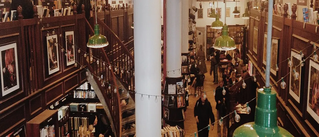 Housing Works Bookstore Cafe interior with wooden tables and reading patrons