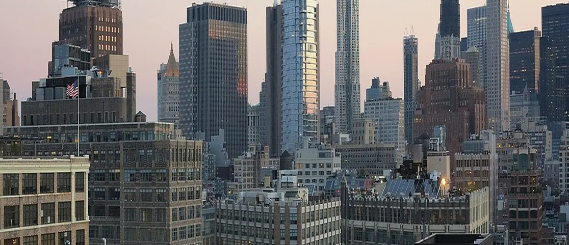Downtown Manhattan rooftop terrace view with colorful cocktail seating and skyline views