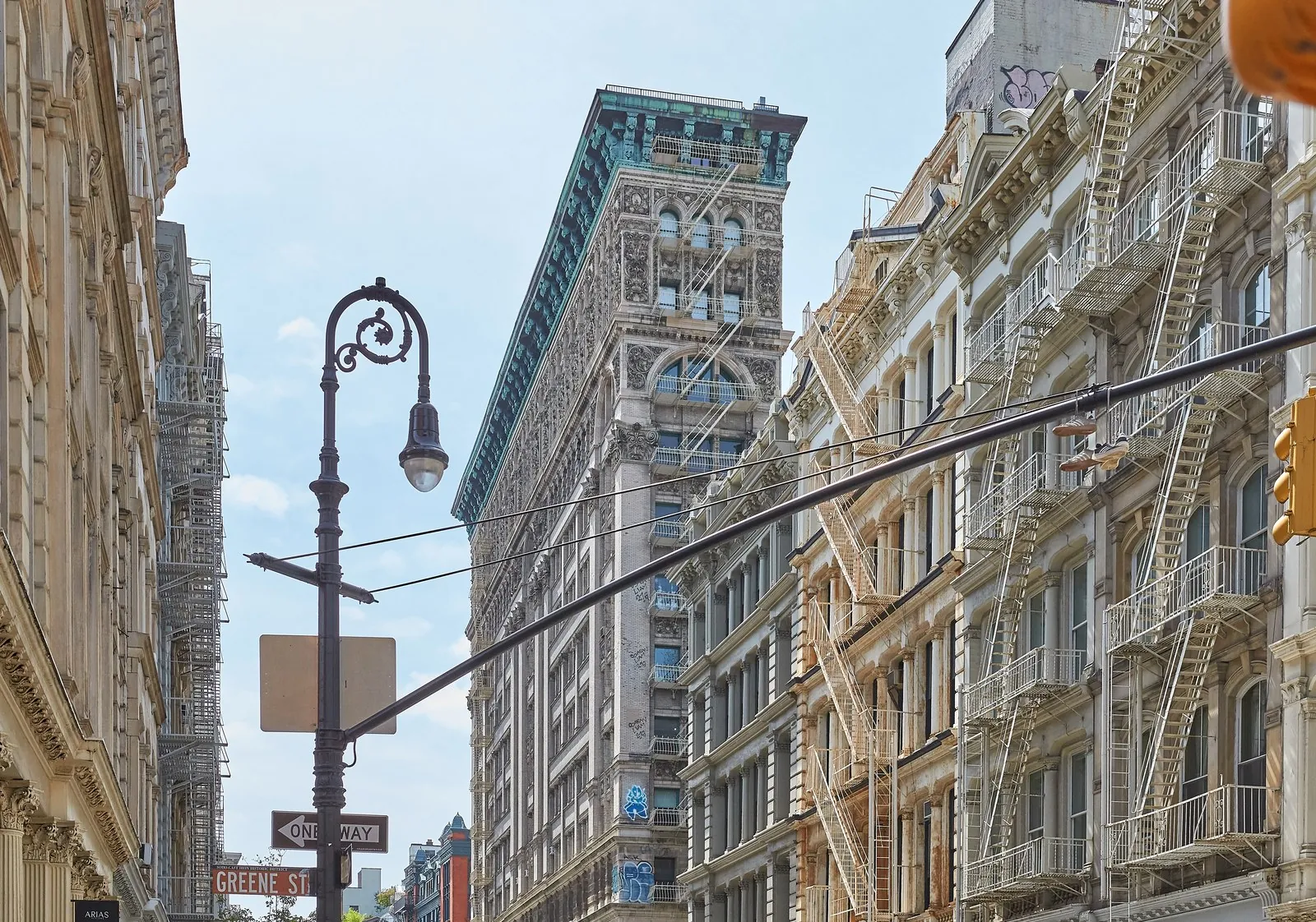 Classic cast-iron facade and historic cobblestone streetscape on Greene Street in SoHo, Manhattan.