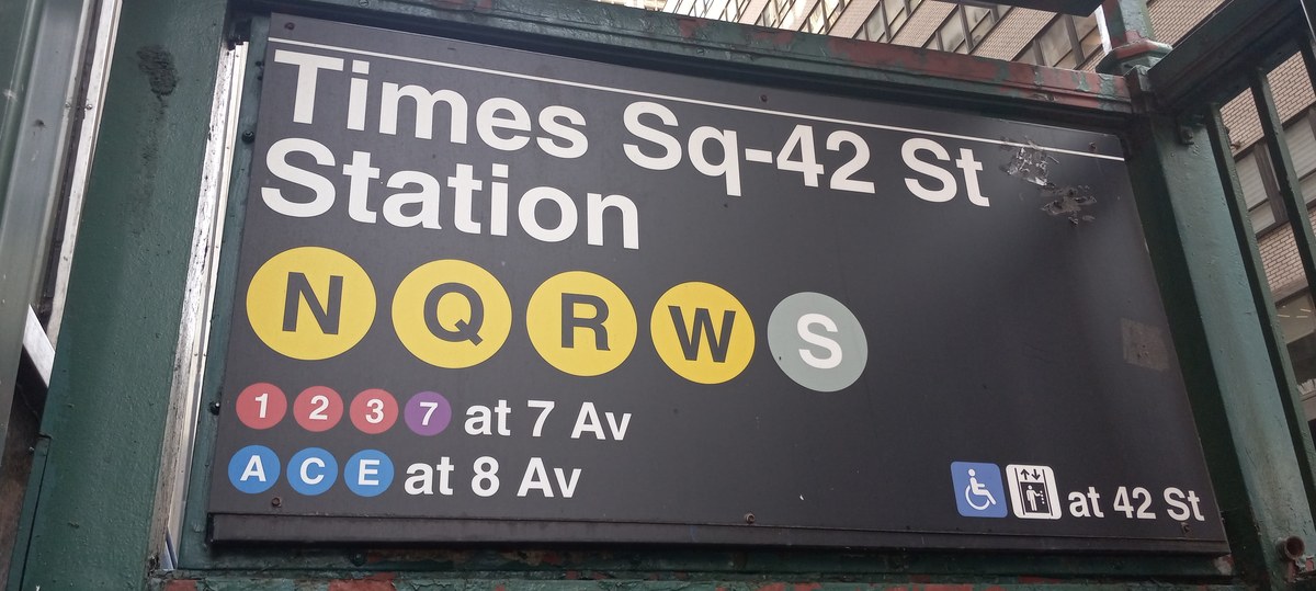 NYC Subway station entrance lamp globe and signage connecting to LaGuardia airport bus