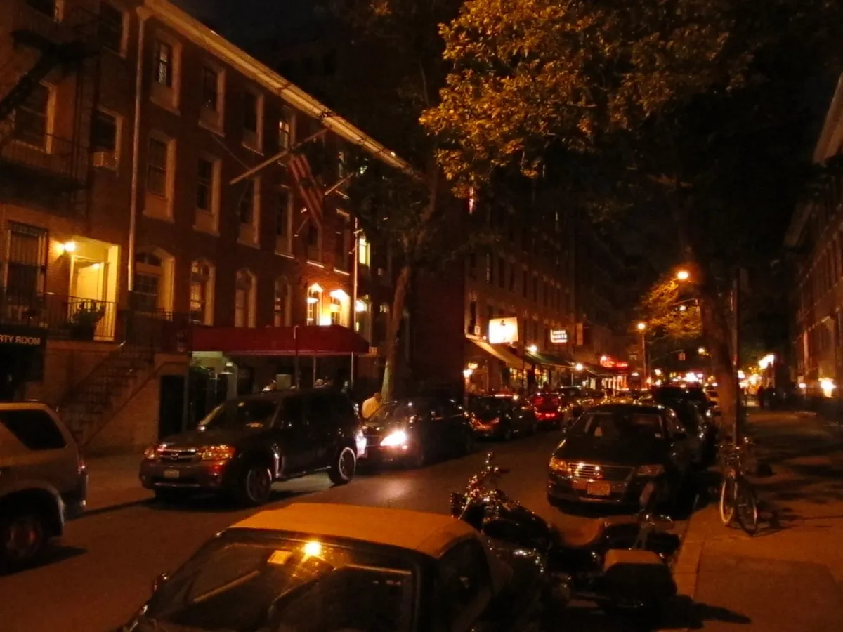 MacDougal Street evening streetscape with glowing storefront lights